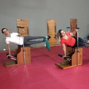 Instrutoras de Pilates fazendo a flexão lateral na Chair durante o 1º Open Vis